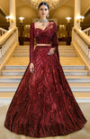 Deep wine red lehenga with heavy sequin embroidery, corset blouse, sheer drape, and embroidered cape.