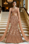 Rose gold hand embroidered mermaid lehenga set with a structured corset blouse and flowing cape.