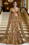 Gold hand-embroidered mermaid lehenga with structured corset blouse and sheer tulle cape.