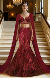 Deep wine red mermaid lehenga with heavy sequin embroidery and sheer net cape with linear designs.