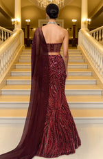 Deep maroon mermaid lehenga with heavy sequin embroidery and sheer net cape with linear patterns.