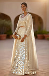 Golden lehenga set with hand-embroidered mirrors and sequins, paired with a sheer pearl cape.