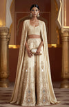Amber lehenga with mirror embroidery, sequins, zardozi, sleeveless blouse, and full-length mirror cape.