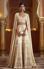 Amber lehenga with mirror embroidery, sequins, zardozi, sleeveless blouse, and full-length mirror cape.