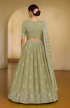 Bog green lehenga set with Kashmiri tilla and zardozi embroidery on blouse, skirt, and dupatta.