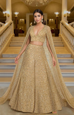 Gold lehenga set with hand-embroidered beads and sequins, deep V-neck blouse, and cape dupatta.