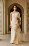 One-shoulder ivory gown featuring embroidered paisley motif and a flowing column silhouette.