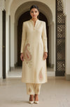Ivory long-line kurta with embroidered paisleys and straight trousers, blending tradition and modernity.